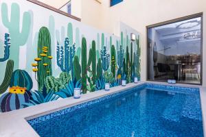 a mural of a swimming pool with cactus at The Townhouses The Pearl in Doha