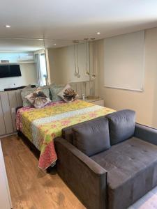 um quarto com uma cama e um sofá em Flat Life Resort com vista pra piscina/lago em Brasília