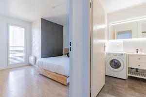 um quarto branco com uma cama e uma máquina de lavar roupa em Urban Pool em Corbeil-Essonnes