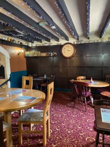 a restaurant with tables and a clock on the wall at Halfway House in Blackwood
