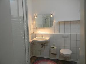 ein Badezimmer mit einem Waschbecken, einem WC und einem Spiegel in der Unterkunft Gästehaus Kehne in Horn-Bad Meinberg