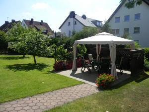 eine Terrasse mit einem Sonnenschirm, einem Tisch und Stühlen in der Unterkunft Gästehaus Kehne in Horn-Bad Meinberg