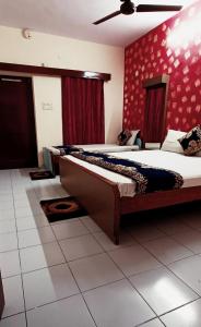 2 camas en una habitación con paredes rojas en Hotel Majors Den, en Nueva Delhi