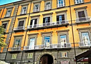 a large yellow building with windows and balconies at Donna Lena Relais Napoli in Naples