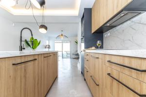kuchnia z drewnianymi szafkami i dużym zlewem w obiekcie Scandinavian style apartment with sea views in a beachfront urbanisation in Calahonda 15 minutes from center of Marbella! w mieście Sitio de Calahonda