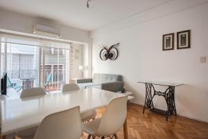 una sala de estar blanca con mesa y sillas en Apartment San Telmo en Buenos Aires