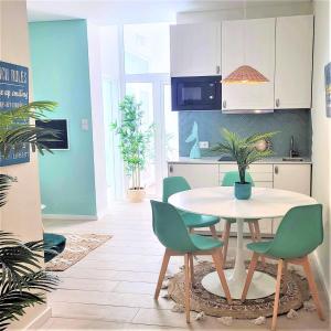 a kitchen with a table and green chairs in a room at The Shore at Seaside Paradise - Cozy Patio on the Promenade in Espinho