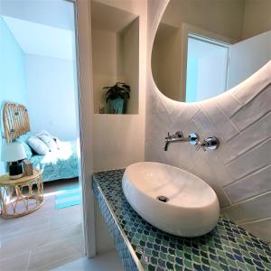 埃斯皮尼奧的住宿－The Shore @ Surf Paradise - Patio Terrasse，一间带水槽和镜子的浴室