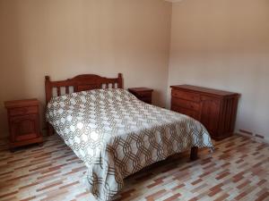 ein Schlafzimmer mit einem Bett und zwei Nachttischen in der Unterkunft Casa Piedra Blanca in Cachí
