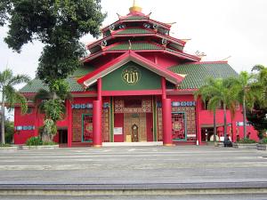 a red building with a gold sign on it at My Studio Hotel Juanda Airport Surabaya in Sedati
