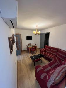 a living room with a red couch and a table at Casa Sculpture in Bogarra