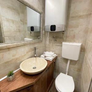 y baño con lavabo, aseo y espejo. en Colorway Apartment en Belgrado