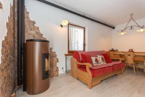 a living room with a fireplace and a red couch at Miralago in Alleghe
