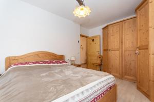 a bedroom with a large bed and wooden cabinets at Miralago in Alleghe