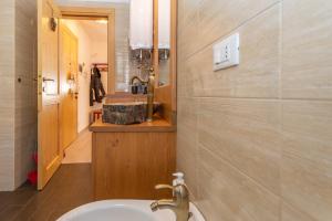 a bathroom with a sink and a mirror and a tub at Miralago in Alleghe