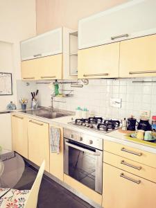 a kitchen with wooden cabinets and a stove top oven at Cinema House in Rome