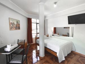 1 dormitorio con cama, mesa y escritorio en Hotel Cordillera Blanca, en Caraz