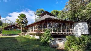 a house in the middle of a yard at Hosteria La Roulotte - Mindo in Mindo