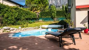 un patio con una mesa y una silla junto a la piscina en La Galante, en Meylan