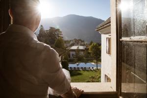 a man looking out a window at the view at Hotel Castel Rundegg (Adults Only) in Merano