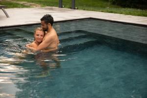 een man en een vrouw in een zwembad bij Hotel Castel Rundegg (Adults Only) in Merano