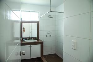 a white bathroom with a sink and a mirror at Condominio Nuevo Paracas in Paracas +44 photos