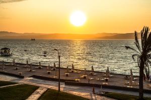 una puesta de sol sobre el agua con un grupo de velas en Condominio Nuevo Paracas, en Paracas