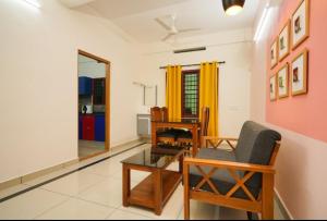 a living room with a chair and a table at Kalapurayil Residency in Kakkanad