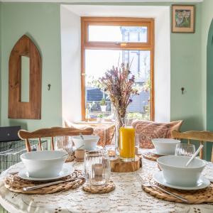 a dining room table with white dishes on it at Quirky Kendal Cottage in Kendal