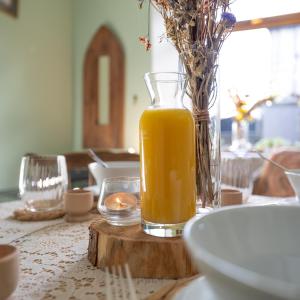 a glass vase of orange juice sitting on a table at Quirky Kendal Cottage in Kendal +48 photos