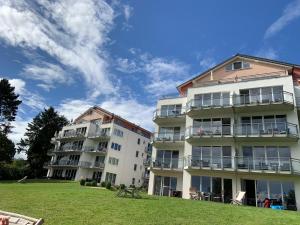 Dos edificios de apartamentos con césped frente a ellos en Fewo-Suite mit Seeblick, en Ascheberg