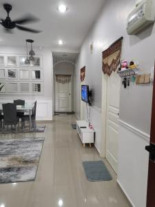 a living room with a table and a white refrigerator at Homestay Qaseh Kerteh in Kertih