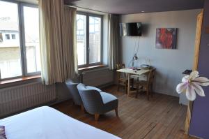 une chambre d'hôtel avec un lit, une table et des chaises dans l'établissement W'allons nous dormir, à Liège