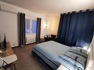 een slaapkamer met een bed met blauwe gordijnen bij Appartement Azur in Balaruc-les-Bains