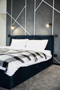 a bedroom with a black and white bed with white pillows at Blog House Resort in Yaremche