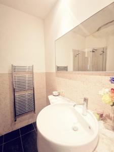 W łazience znajduje się biała umywalka i lustro. w obiekcie Cinema House w Rzymie