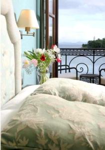 a bed with a flower arrangement on it next to a window at La Boheme in Gythio