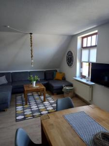 een woonkamer met een blauwe bank en een tafel bij Ostsee Ferienwohnung Pelzerhaken in Neustadt in Holstein