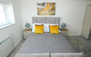 1 dormitorio con 1 cama con 2 almohadas amarillas en The Swell - Avondale One Bed, en Rhosneigr