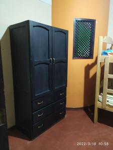 a black dresser in a room with a bed at Don Ramirez in Leticia