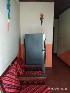 Habitación con sofá y nevera en la pared. en Don Ramirez, en Leticia