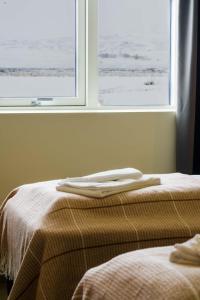two beds in a room with a window at Fljótsbakki Hotel in Godafoss