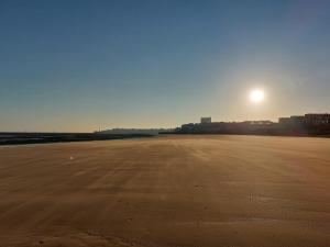 an empty beach with the sun in the sky at Westbrook Lodge Guest House in Margate