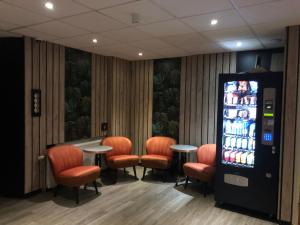 een drankenautomaat in een kamer met oranje stoelen bij Amsterdam Downtown Hotel in Amsterdam