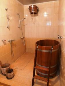 a bathroom with a wooden tub and a shower at Sadyba na Gutsulsky Polonyni in Tatariv
