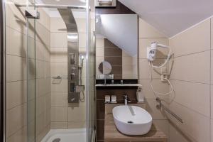 
a bathroom with a toilet, sink, and shower stall at Bazilika alatt Panzió in Esztergom
