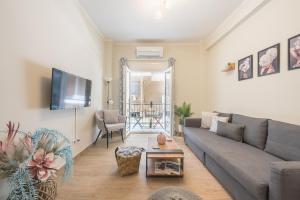 ein Wohnzimmer mit einem Sofa und einem TV in der Unterkunft Easy Living Suite by Cloudkeys in Athen