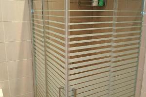 W łazience znajduje się prysznic ze szklanymi drzwiami. w obiekcie Paris house 3 w mieście Patras