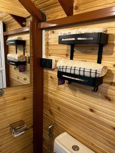 baño con aseo y pared de madera en Cinnamon View Lodge Mirissa en Mirissa