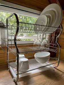 a metal shelf with dishes and plates on a window at Cinnamon View Lodge Mirissa in Mirissa